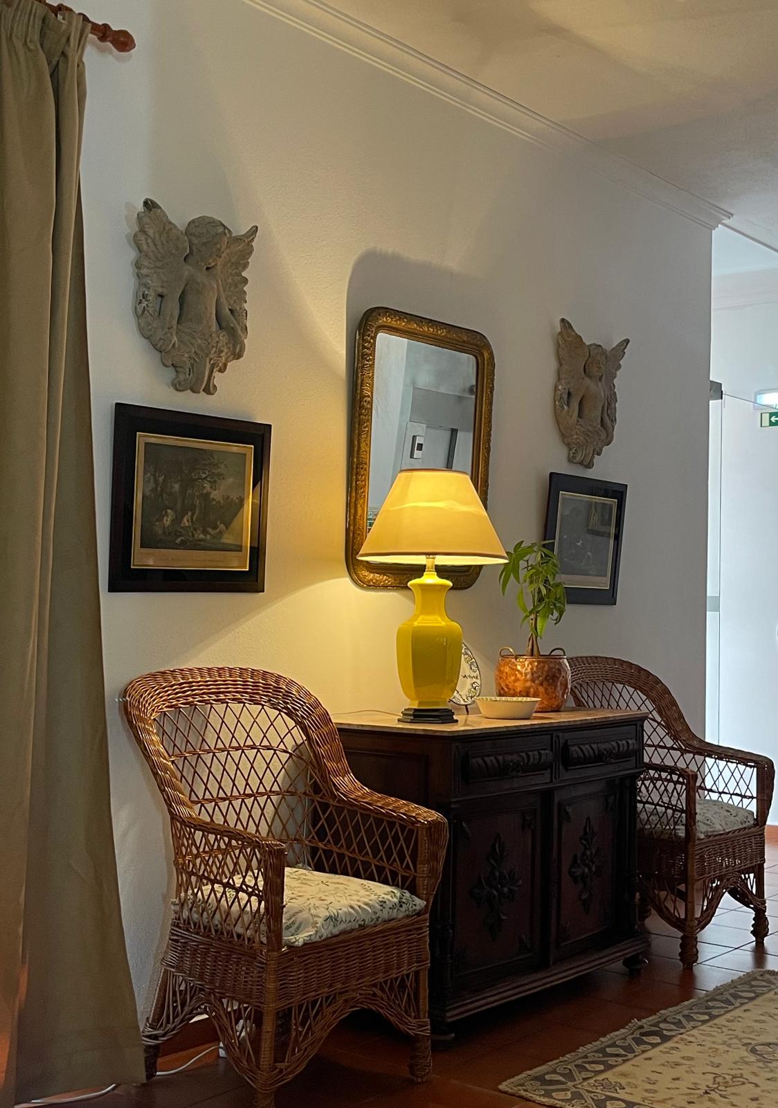 Entrada com consola antiga, espelho dourado e candeeiro