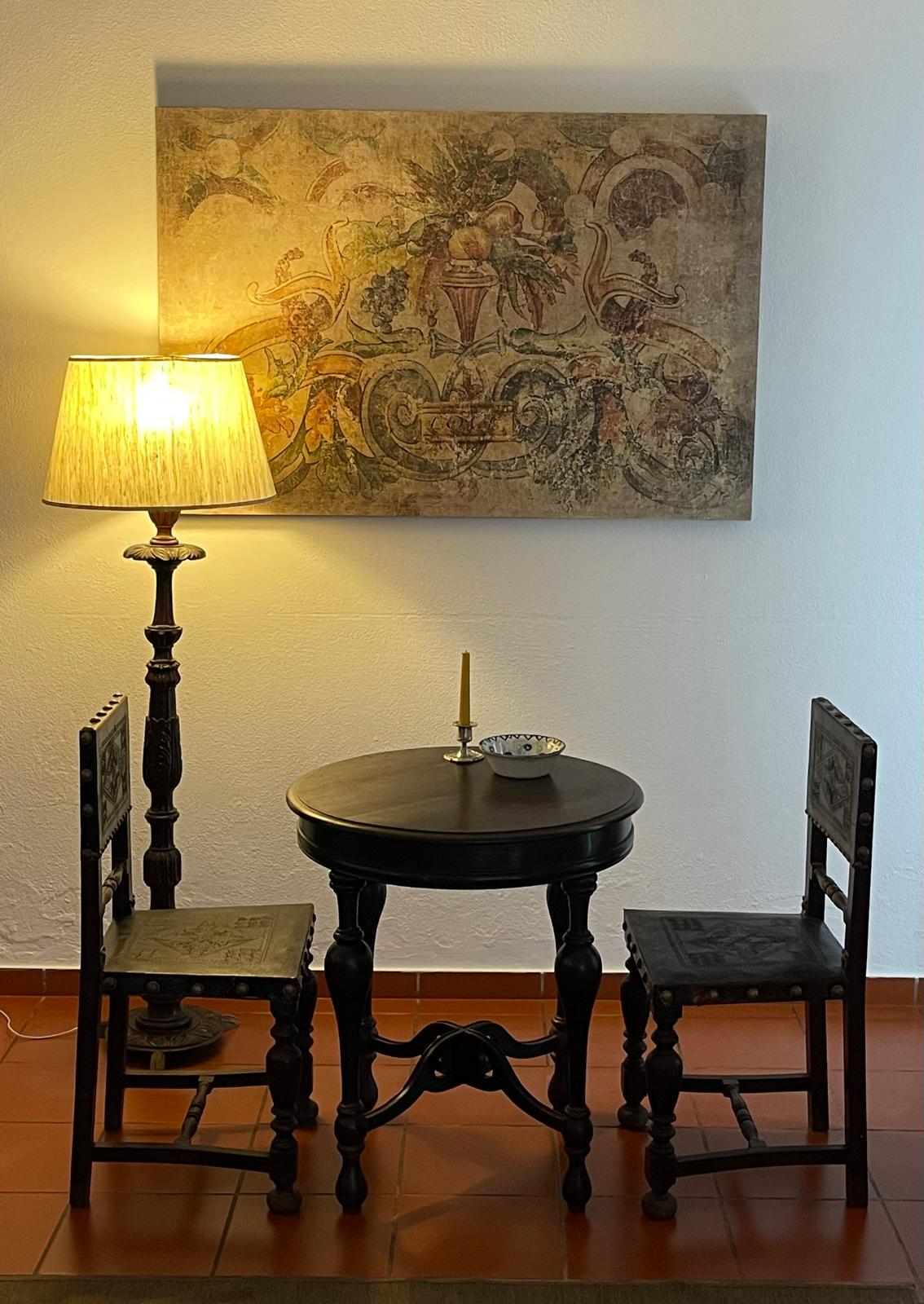 Detalhe interior da Vila JC com candeeiro e mobiliário antigo